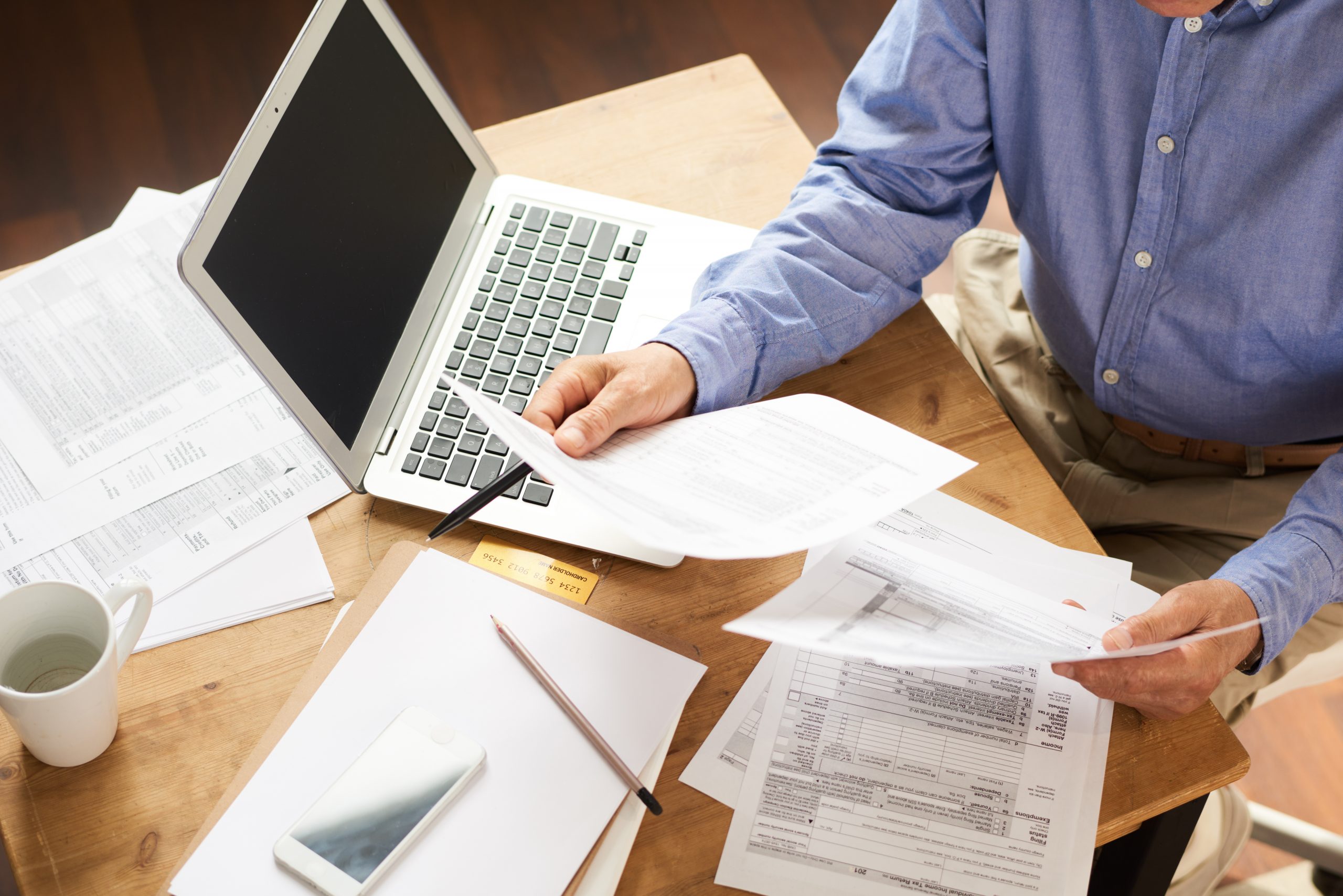 A man sitting at a table filing his federal return during tax season.