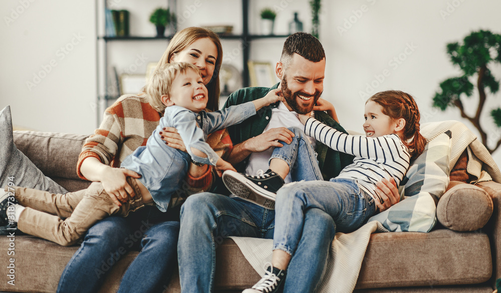 A family sitting together in the kitchen, with the mom showing photos on her phone.
