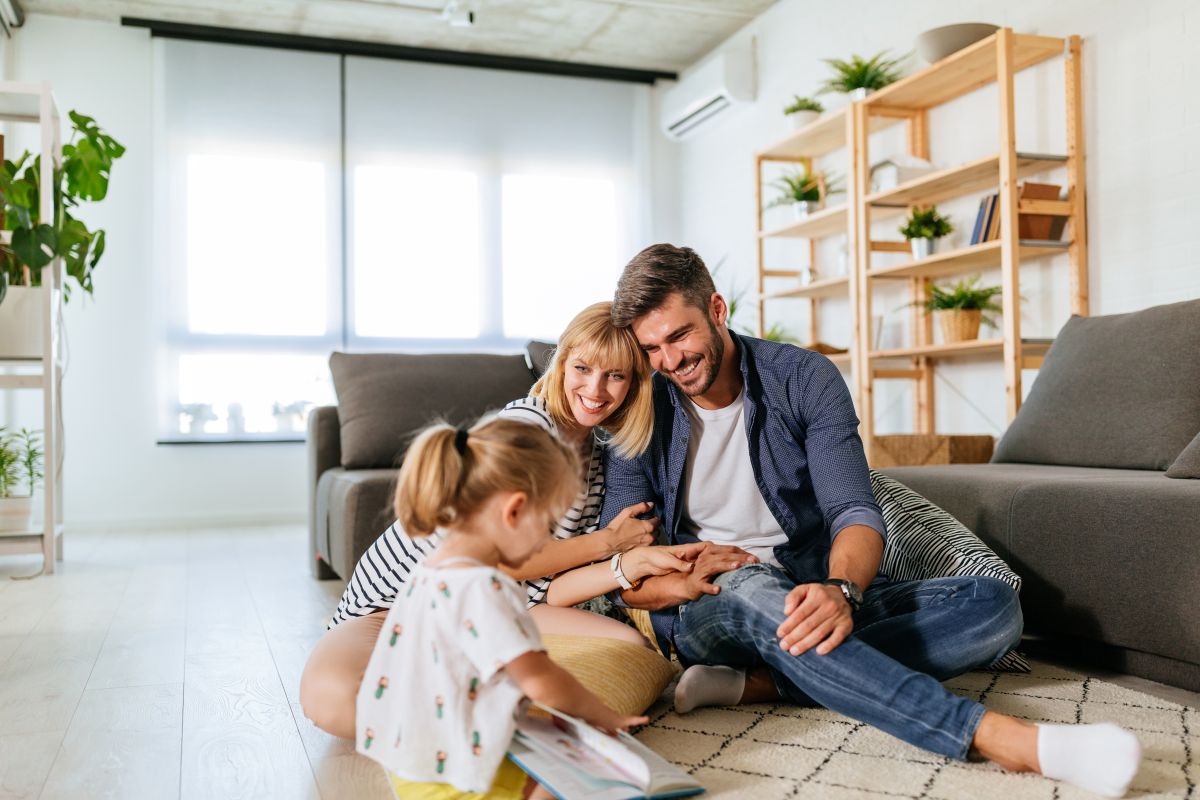 Parents sitting in the living room with their young daughter