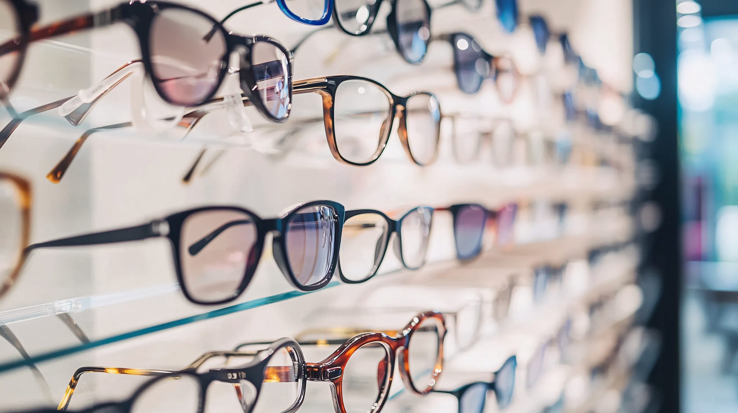A display rack in a vision care shop shows a selection of eyeglasses.