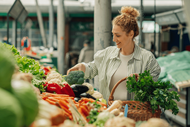 A woman selecting vegetables at an Idaho farmers market.